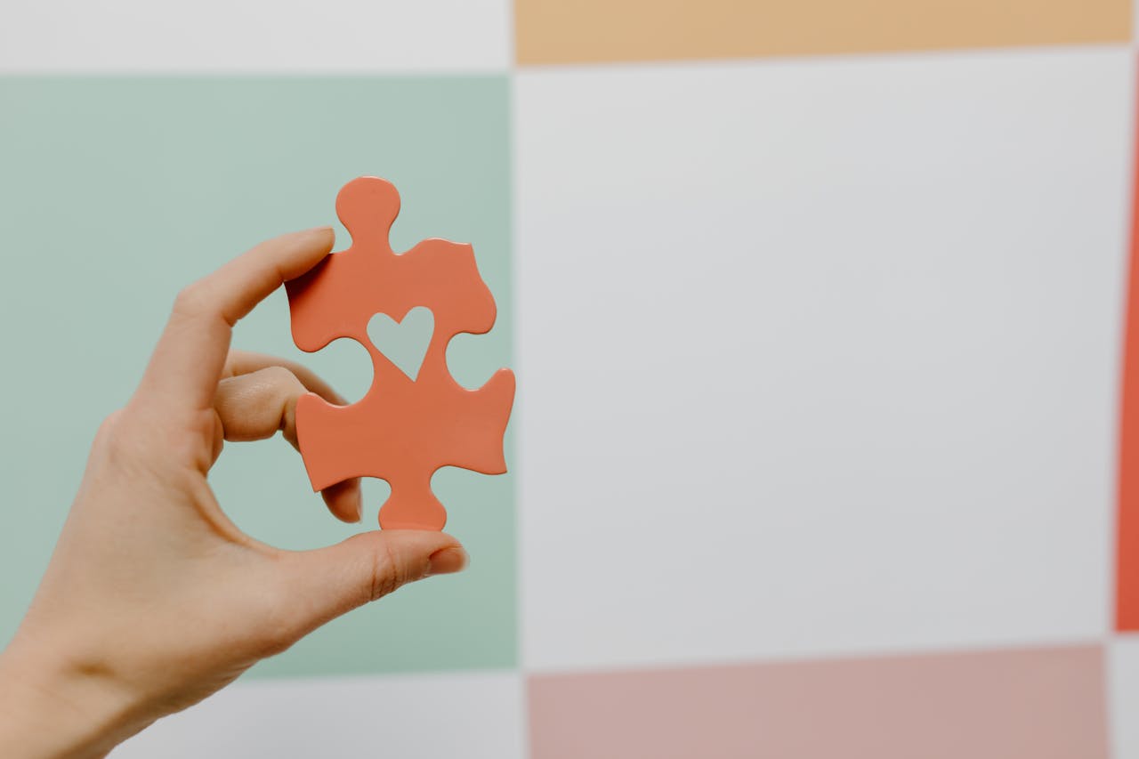 Close-up of Person Holding a Puzzle Piece with a Heart